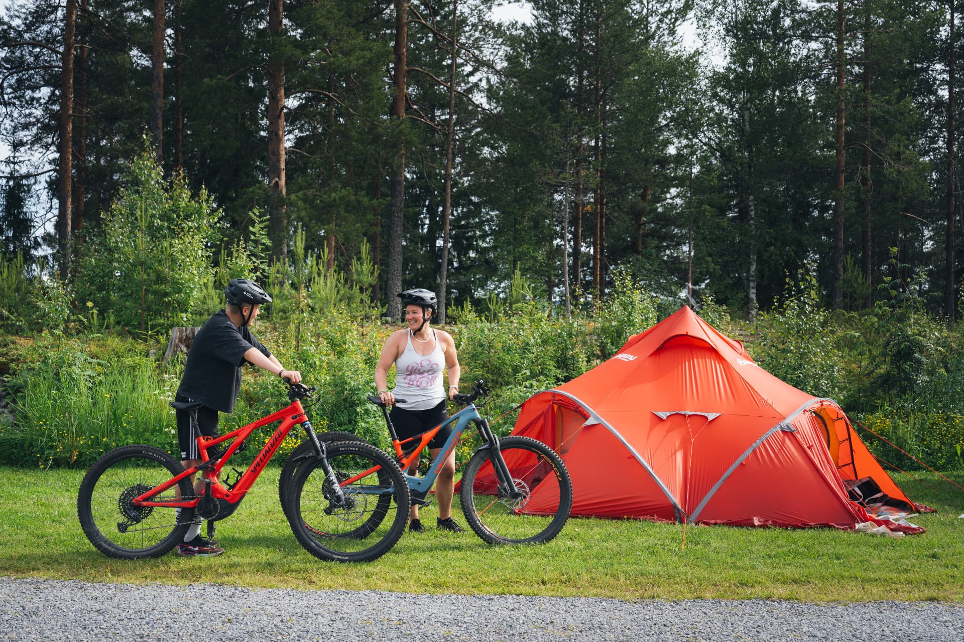 Cyklister och tält i grön miljö