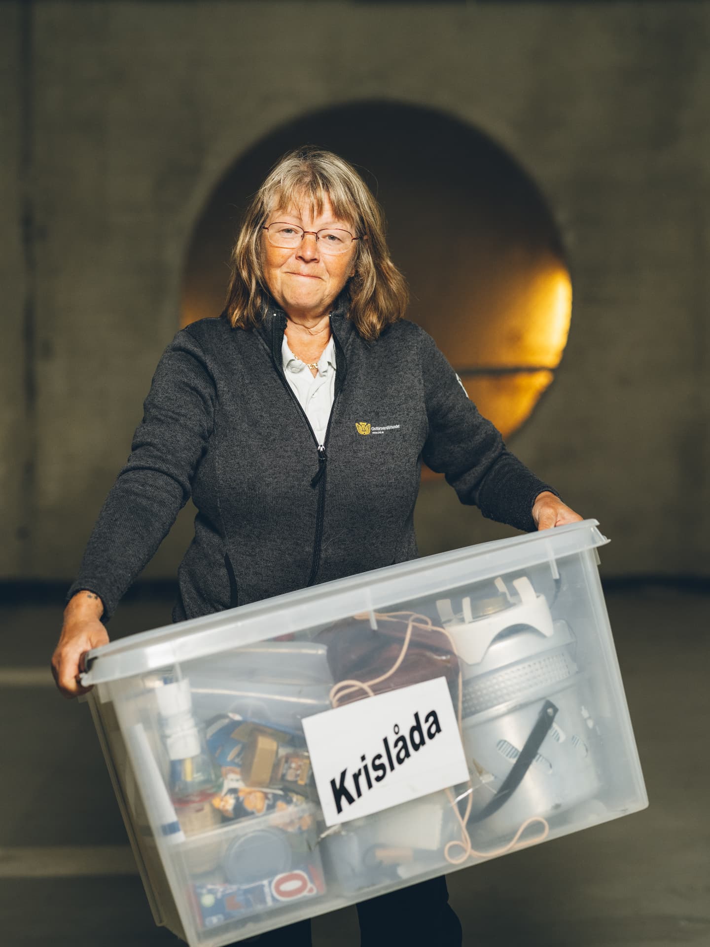 Kvinna bär en låda med återbrukade föremål