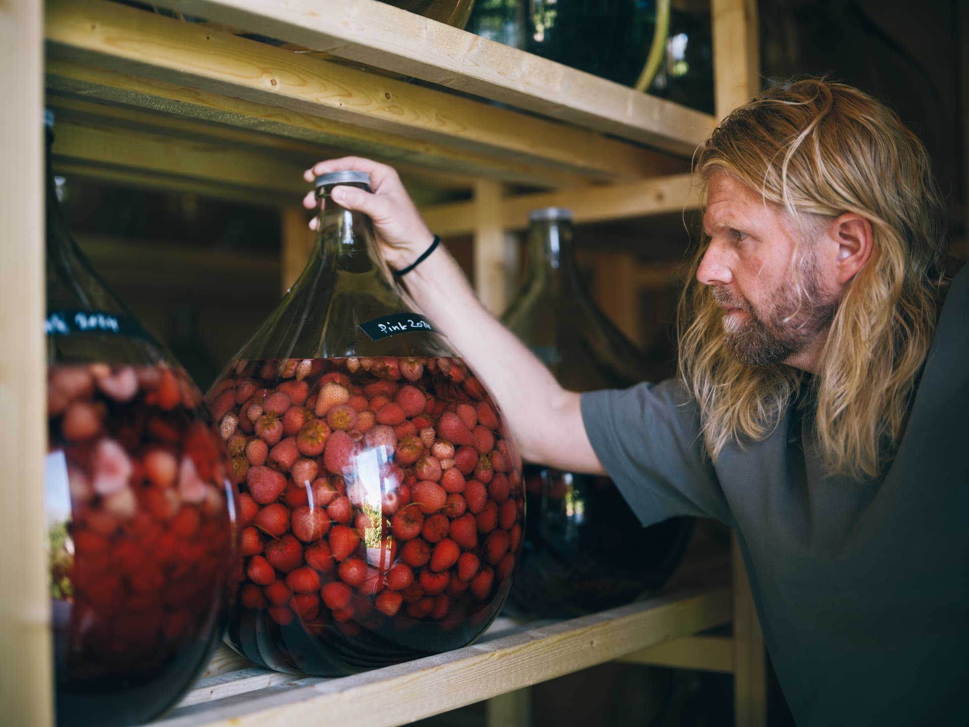 Man med jordgubbar i glasbehållare