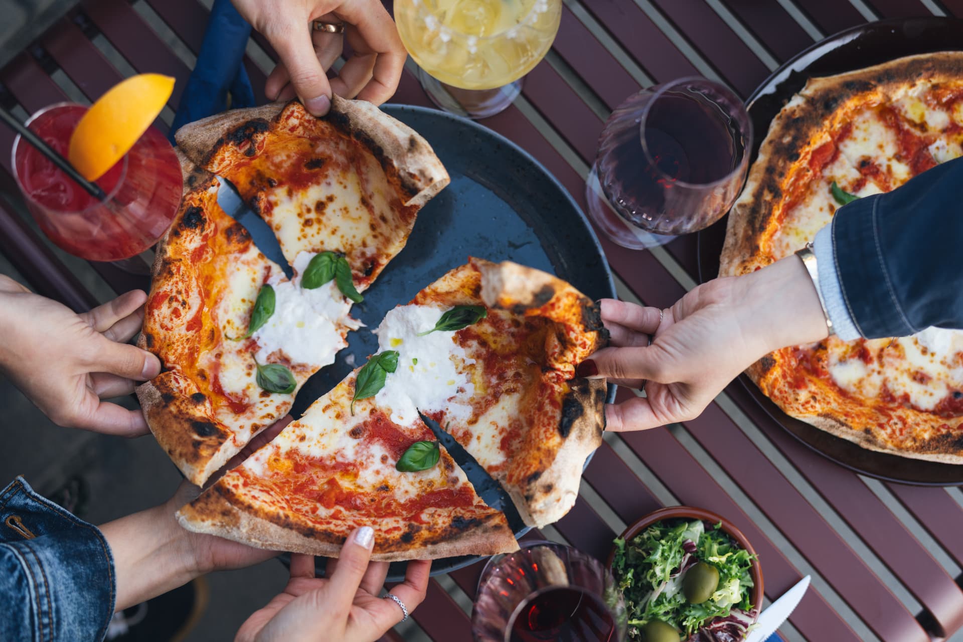 Sällskap delar pizza på uteservering